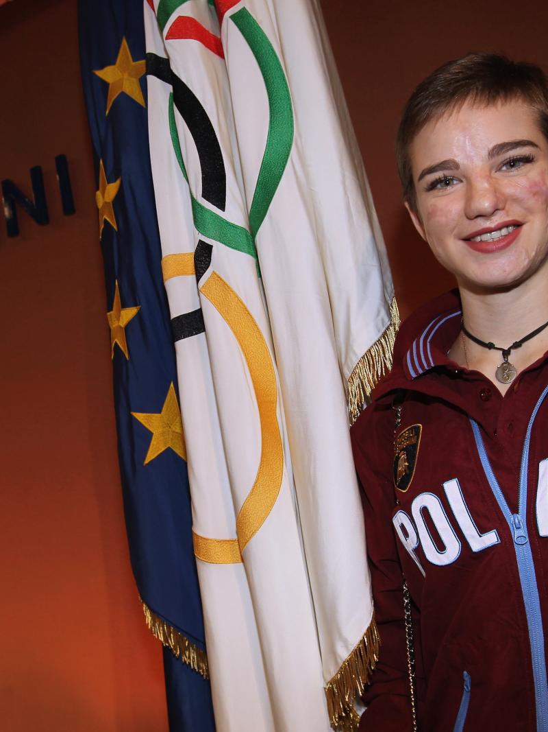 an female Para athlete smiles in front of an Italian flag