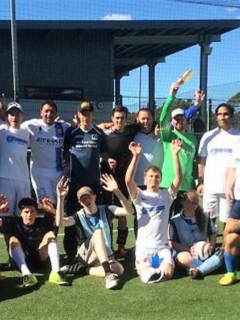 a group of blind footballers smile at the camera