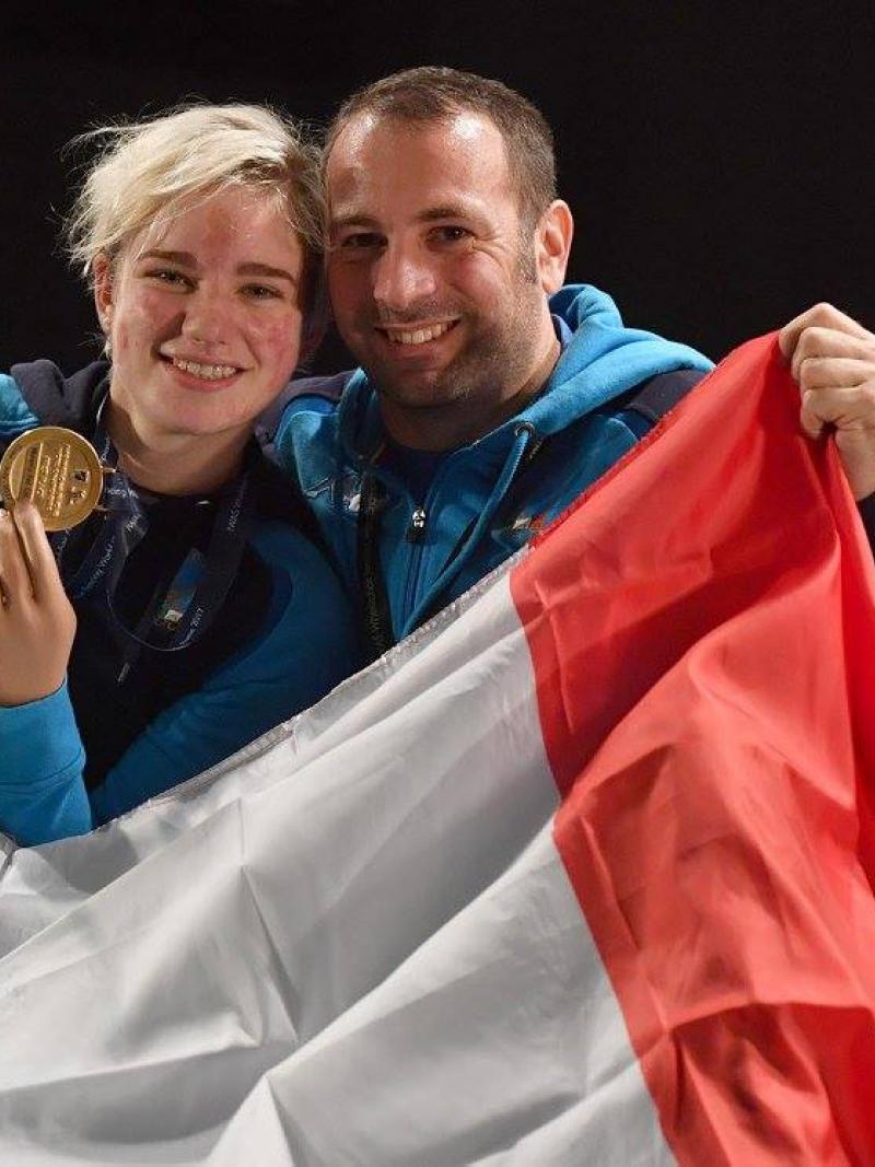 a man a woman smiling with a gold medal and the Italian flag