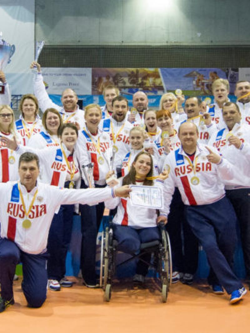 a group of male and female sitting volleyball players celebrate