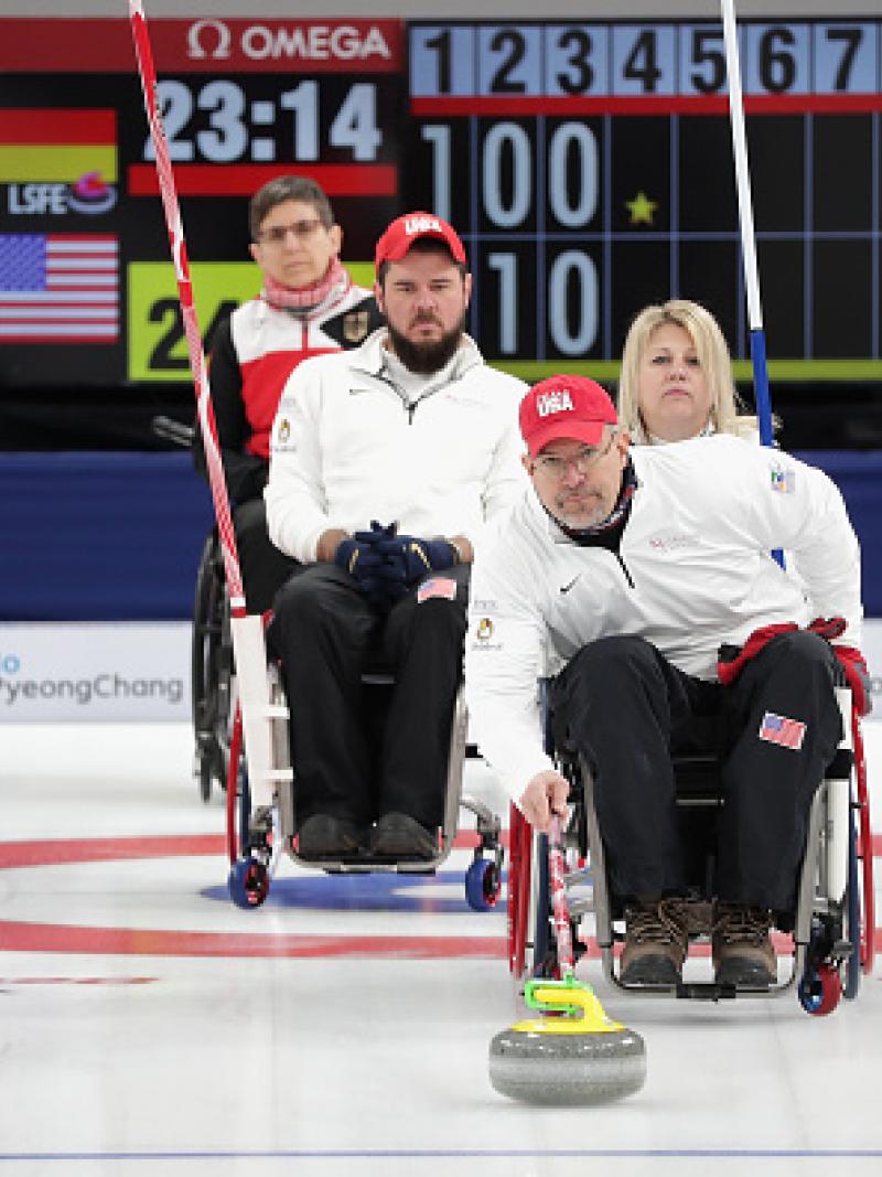 Wheelchair curlers competing on the ice