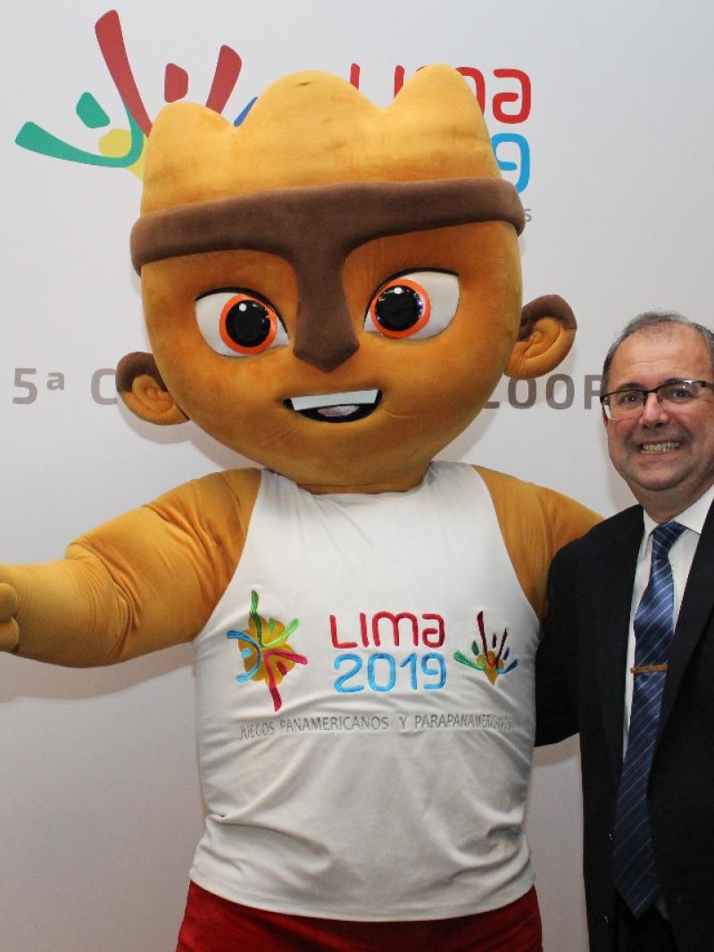 A cuddly mascot and a man give a thumbs up to the camera