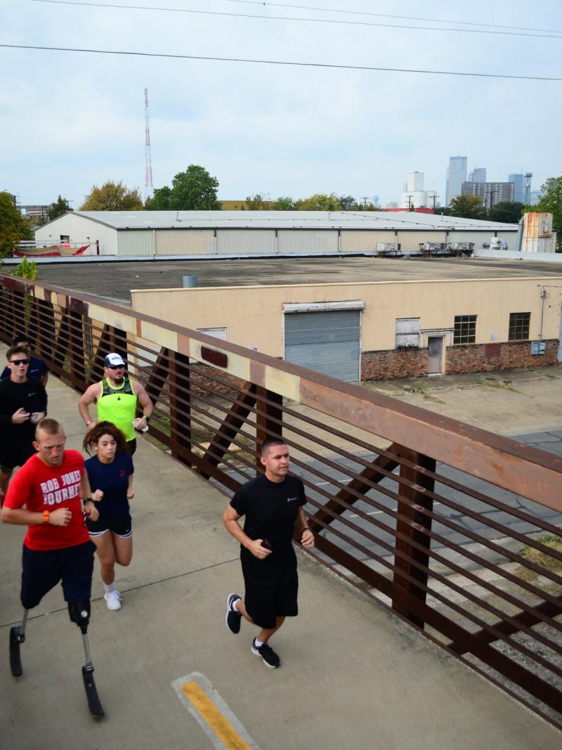 Double amputee running with group of people running behind him
