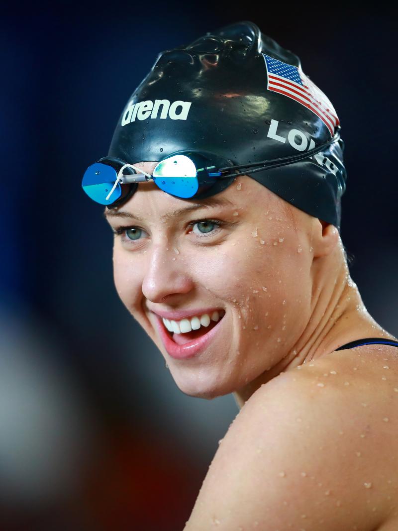 a female Para swimmer smiles after winning her race