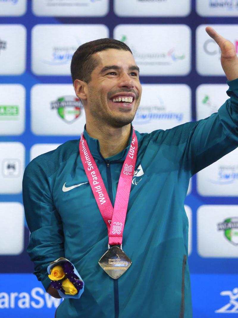 a male Para swimmer celebrates on the podium