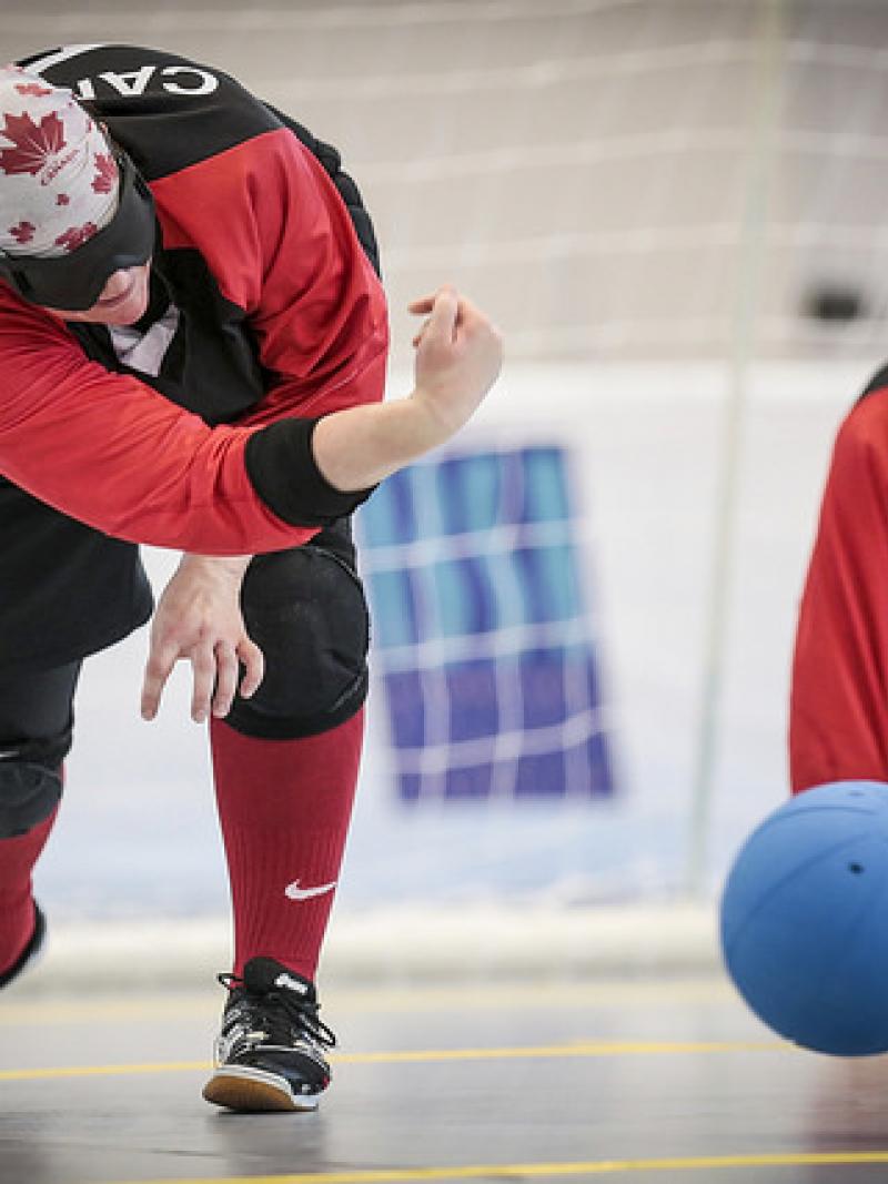 Woman goalball player rolls a ball