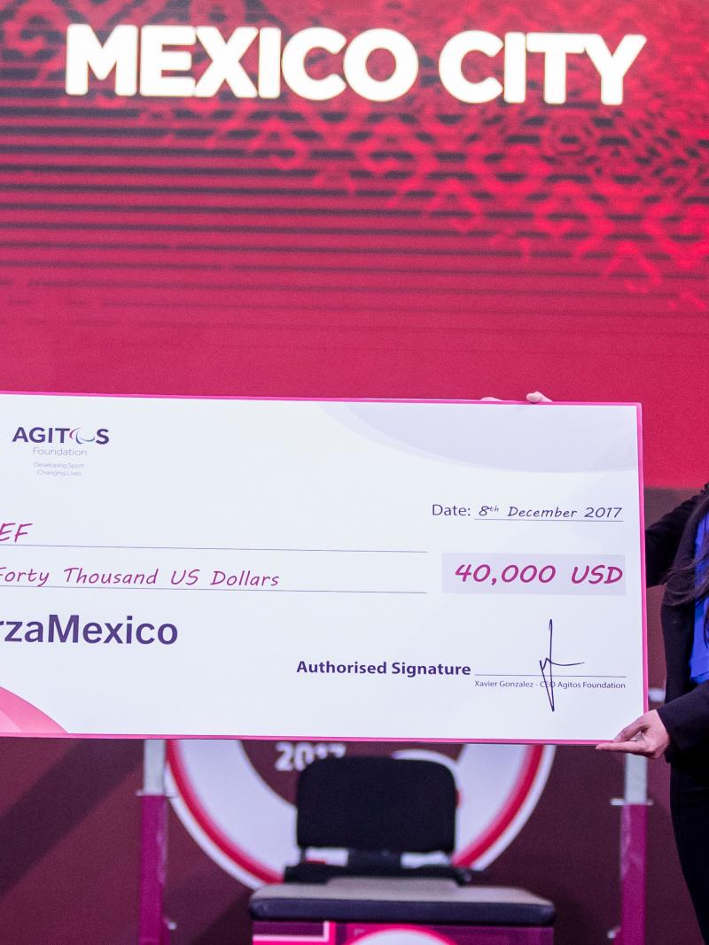 IPC President Andrew Parsons presents the cheque to UNICEF representative Jimena Lazcano