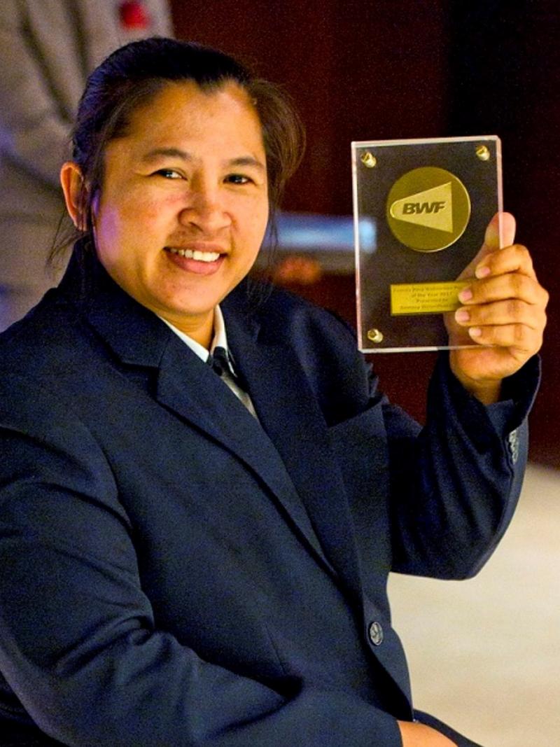 a female Para badminton player holds up an award