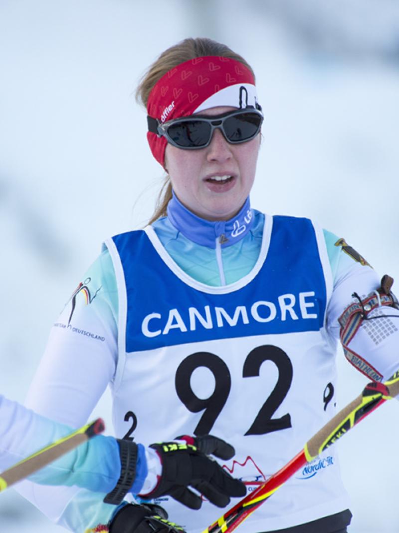 Two people talking, one on the right is competing in Para Nordic Skiing
