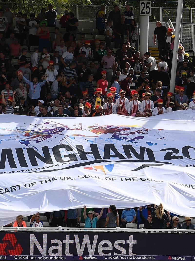 a huge flag is held up by a crowd of cricket supporters