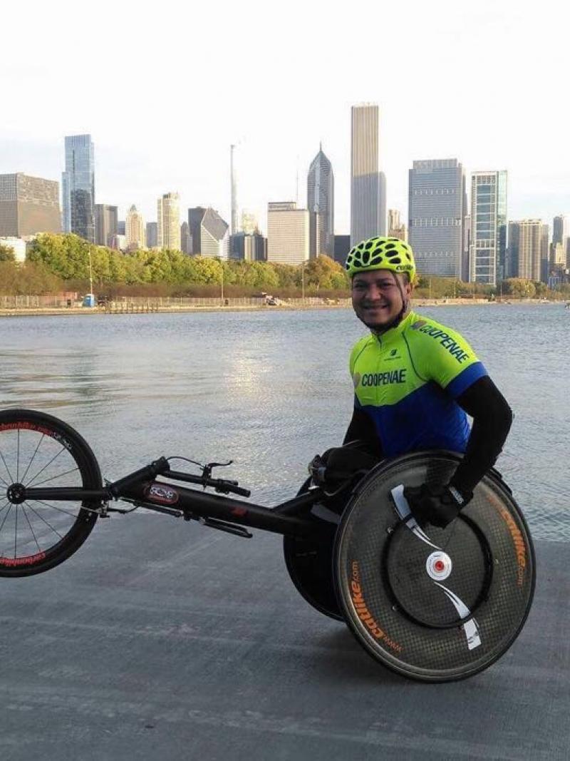 a male wheelchair racer in front of a city skyline
