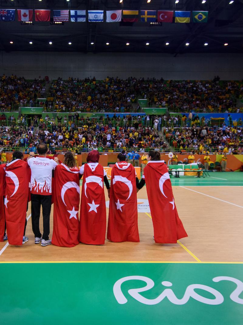 a group of women hug under the Turkish flag
