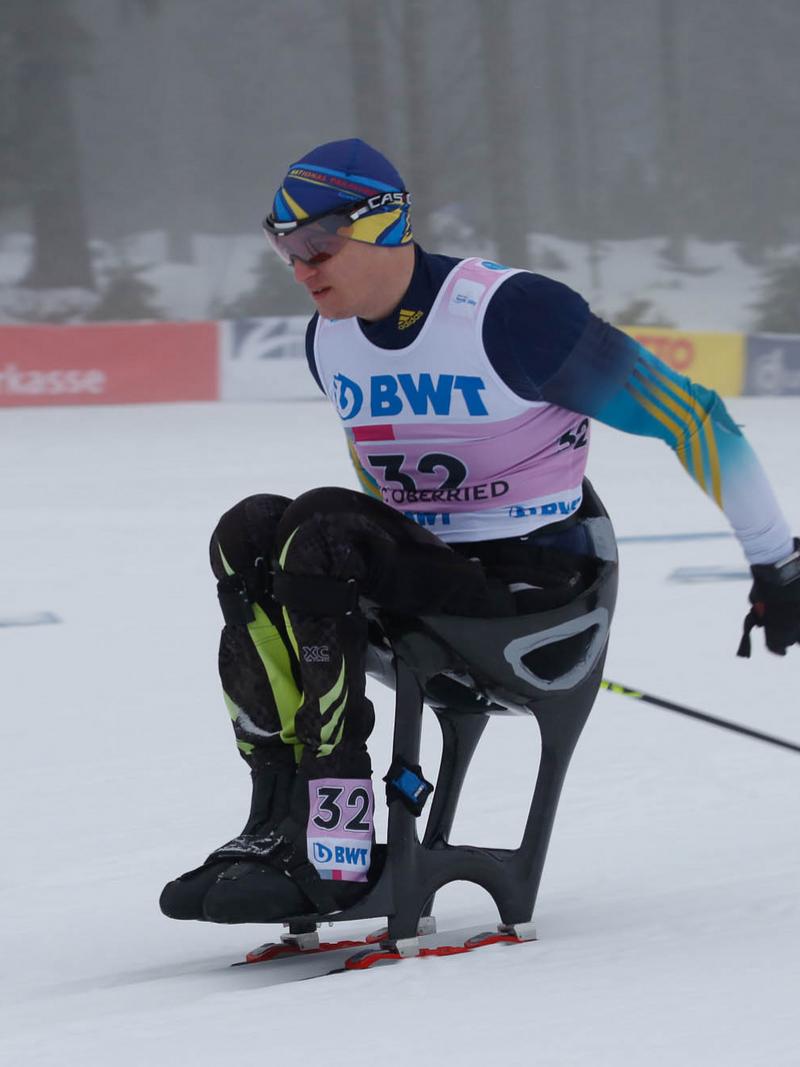 a male sit skier ploughs through the snow