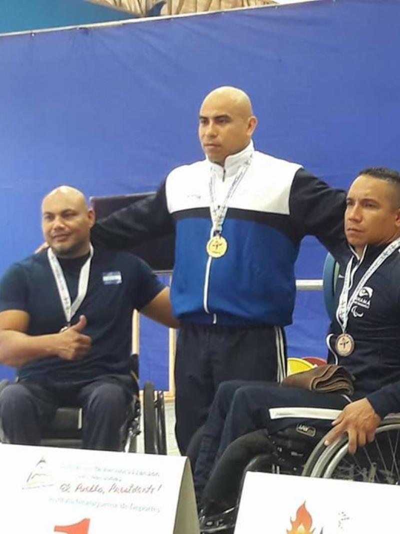 three male powerlifters ona podium
