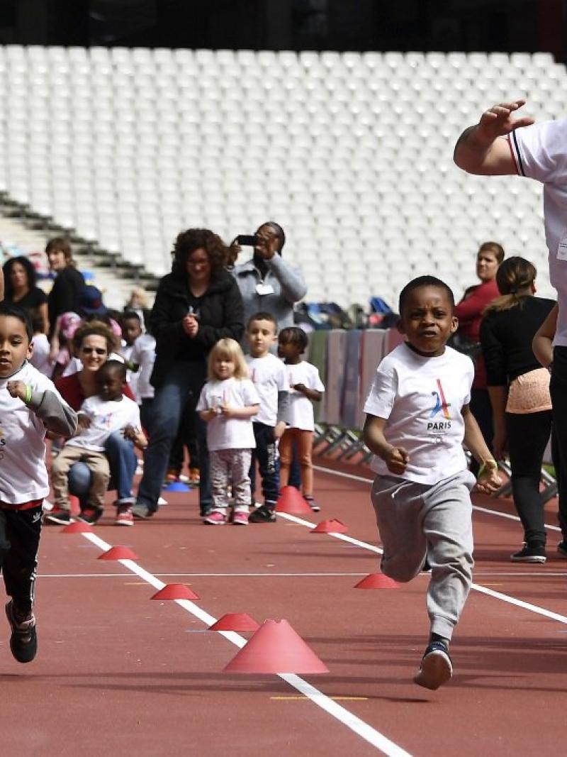 Men and children running on an athletics' track