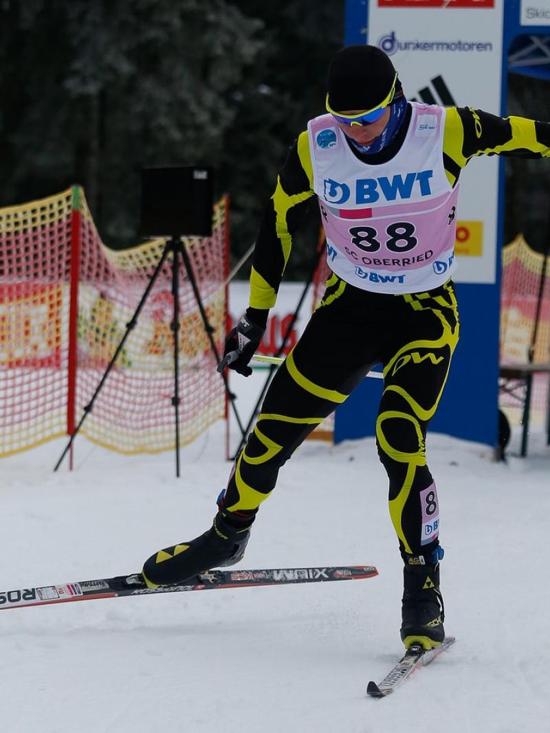 A male Para Nordic skier sprints towards the finish line