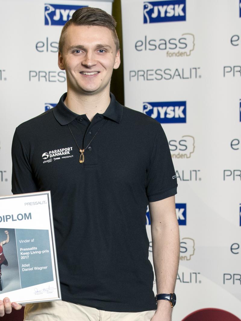 a male Para athlete holds up a certificate