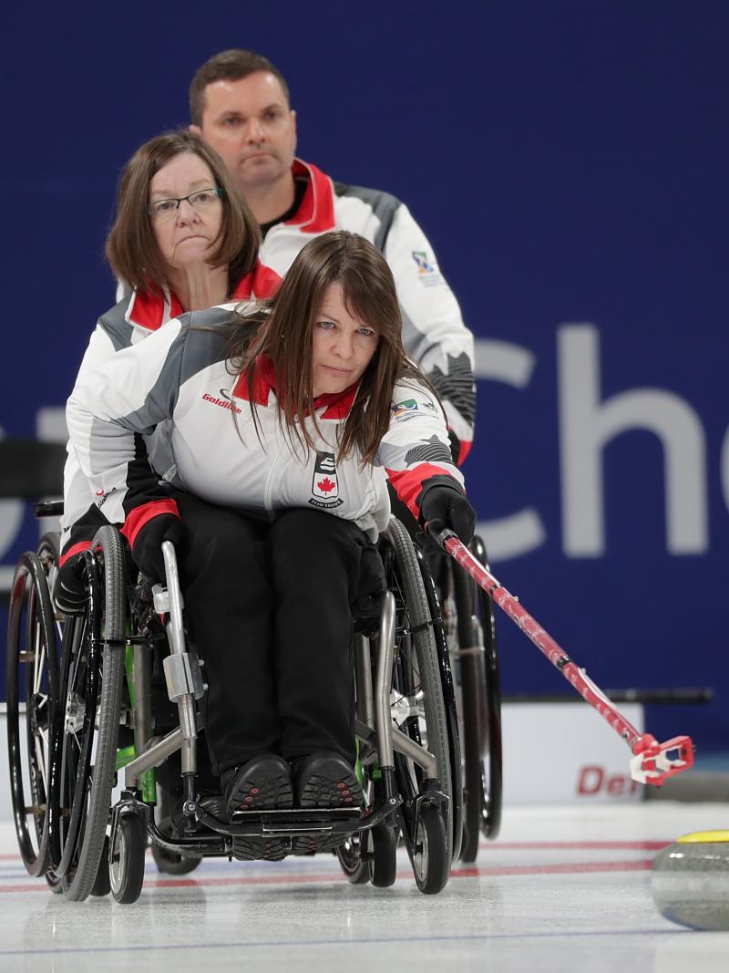 a female wheelchair curling releases a stone