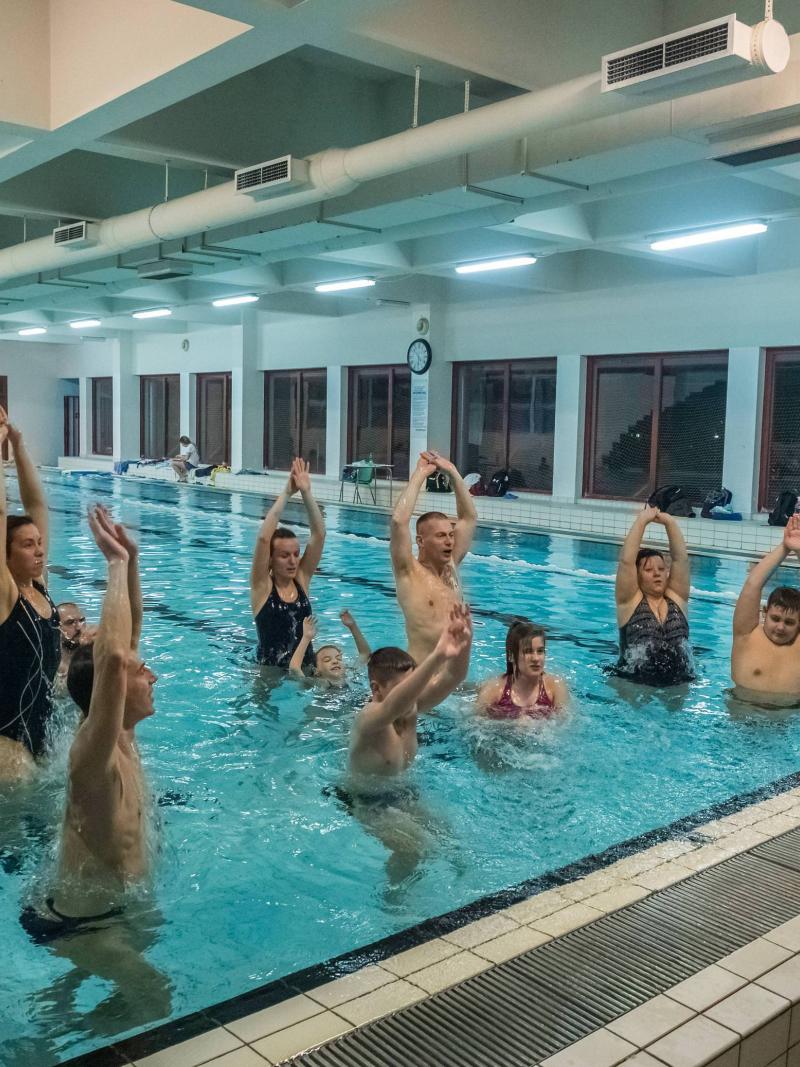 Expert trainers and athletes teaching children how to swim