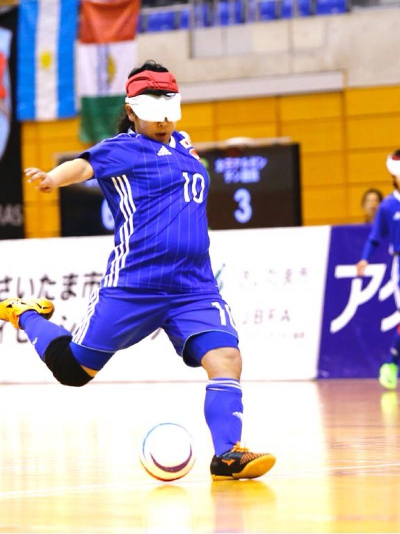 a female blind footballer takes a shot