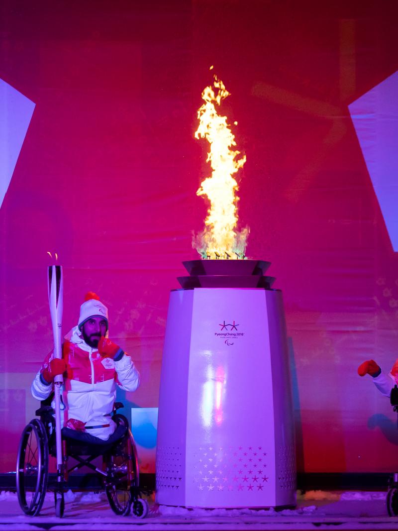 two athletes light a flame