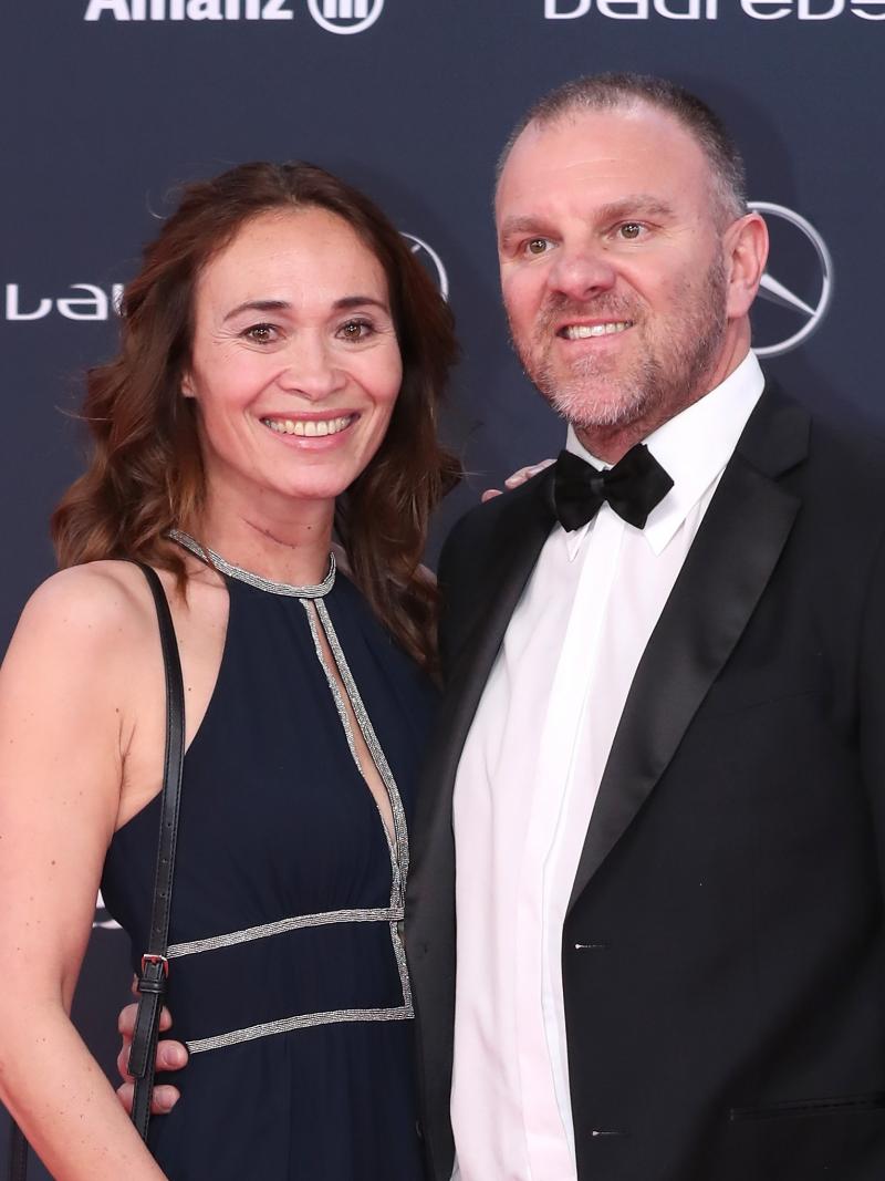 a woman and man stand on the red carpet