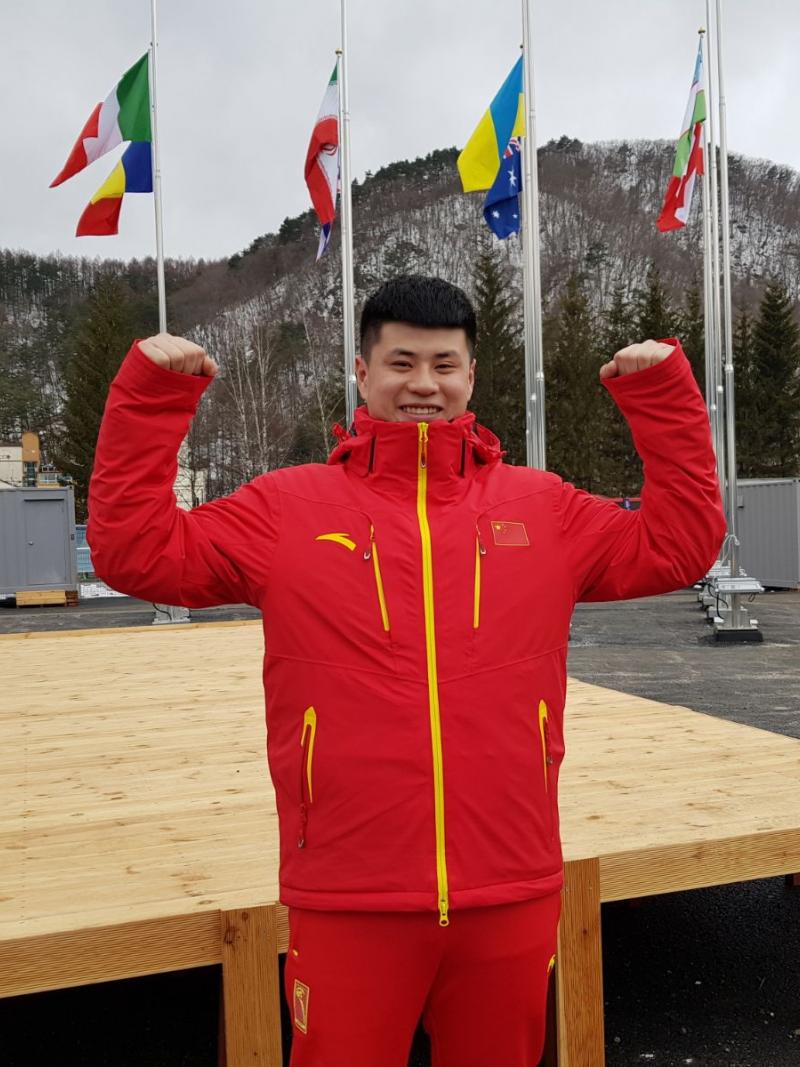 a male Para snowboarder gives a thumbs up