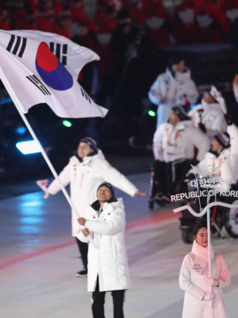 an athlete holds a South Korean flag