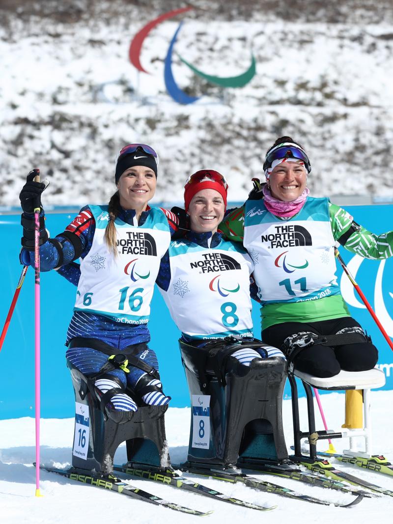 three female Nordic skiers hugging