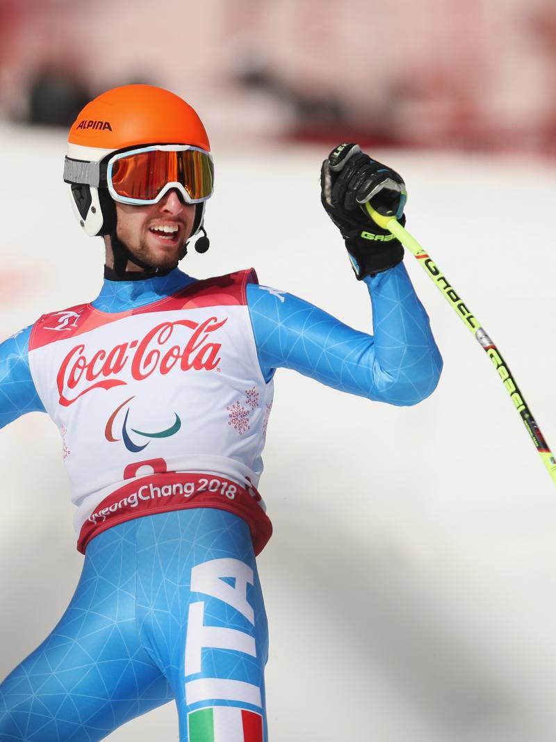 a male Para alpine skier celebrates on the slope