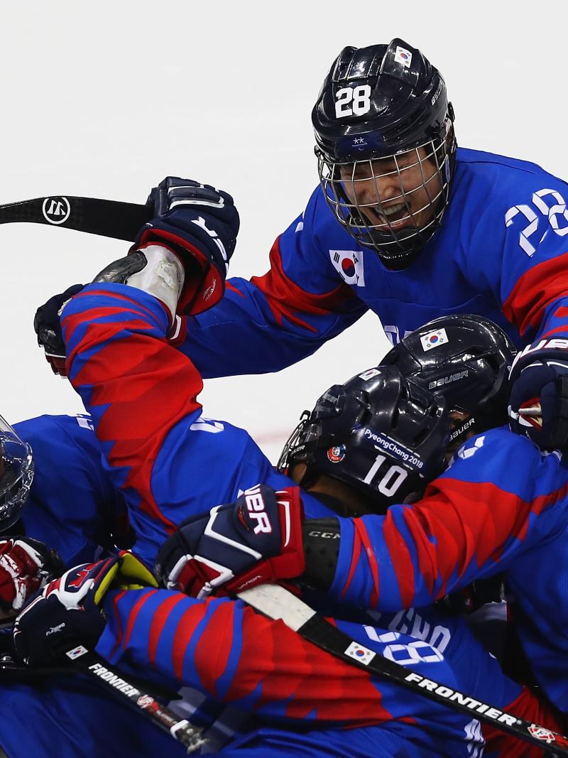 a Para ice hockey team hug in celebration