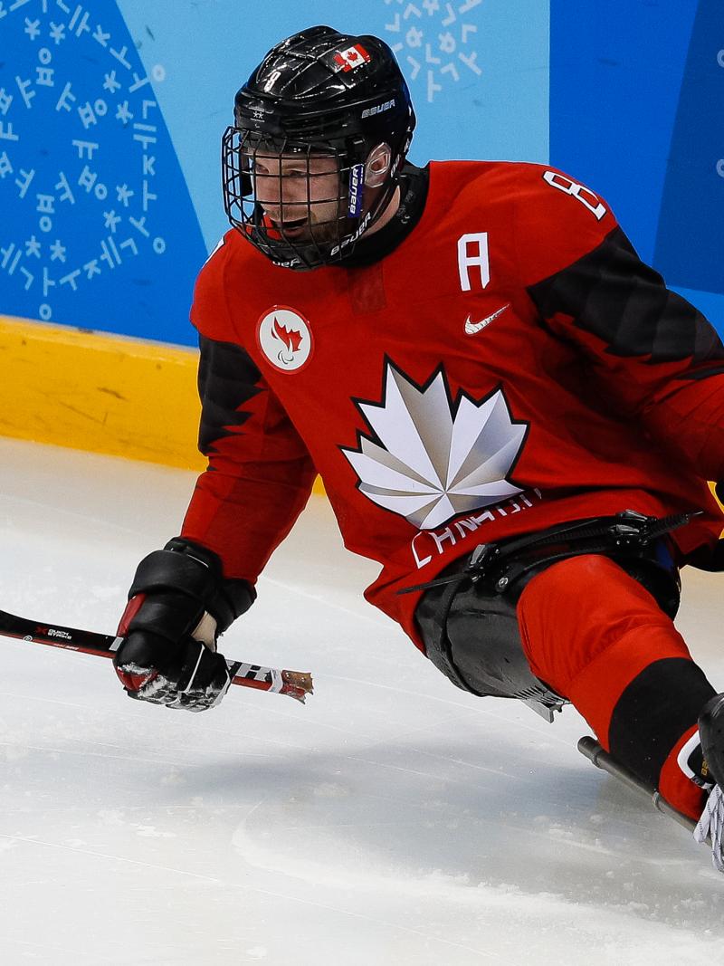 a male Para ice hockey player celebrates a goal