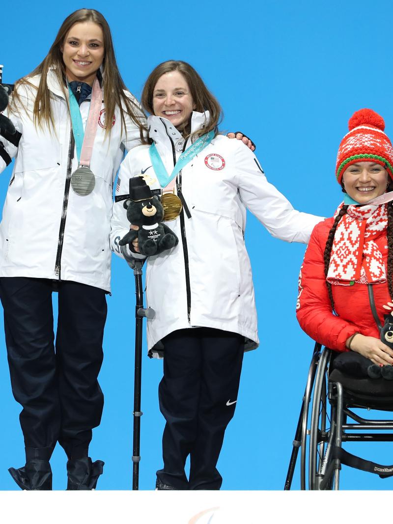 three female sit skiers on the podium with their medals