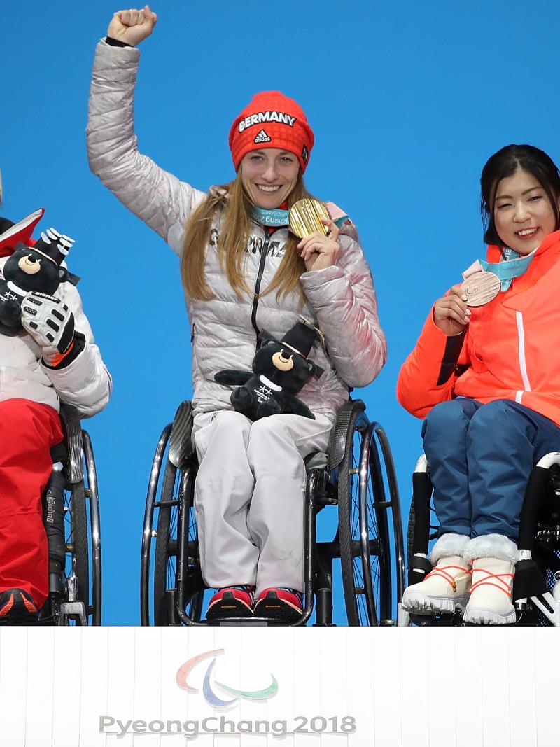 three female sit skiers on the podium with their medals
