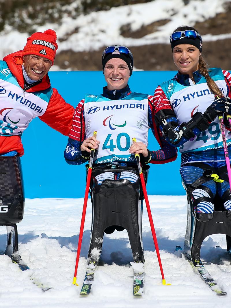 three female sit skiers celebrate their medals