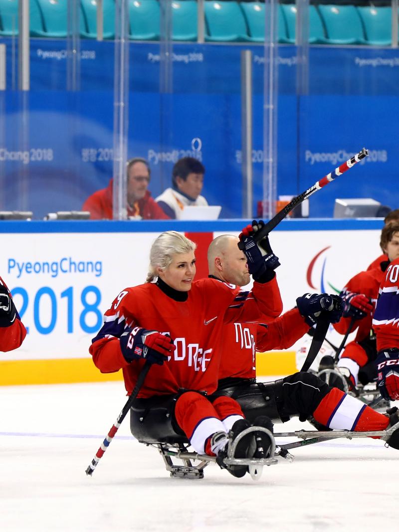 a group of Para ice hockey players celebrating the ice hockey