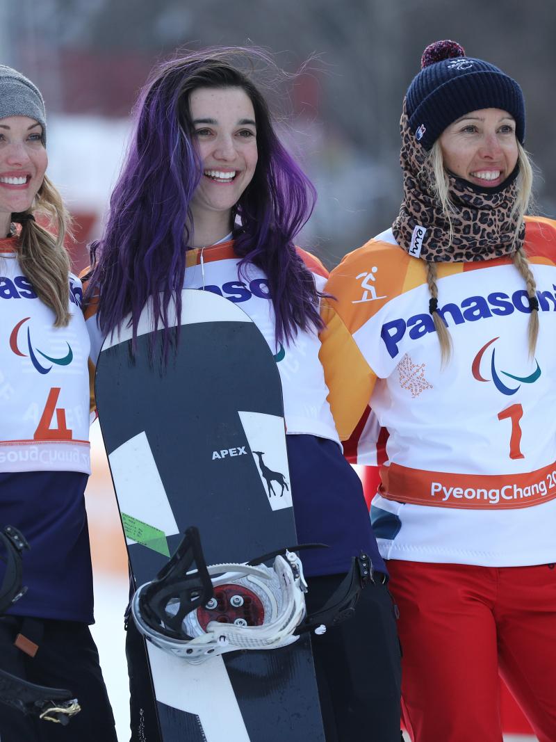 three female snowboarders on a podium