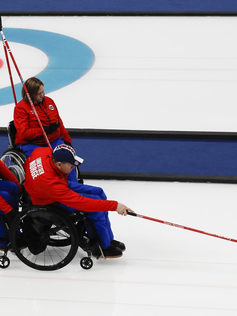 wheelchair curler throws a stone