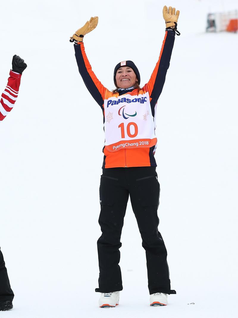 three female snowboarders jump in the air