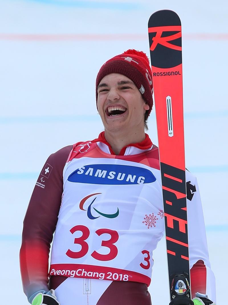 a male Para skier laughs in celebration