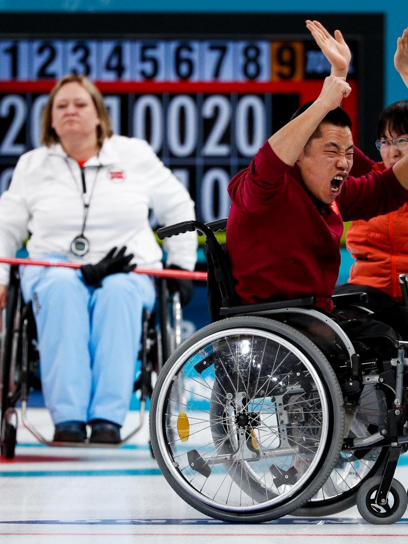 wheelchair curlers celebrating on the ice