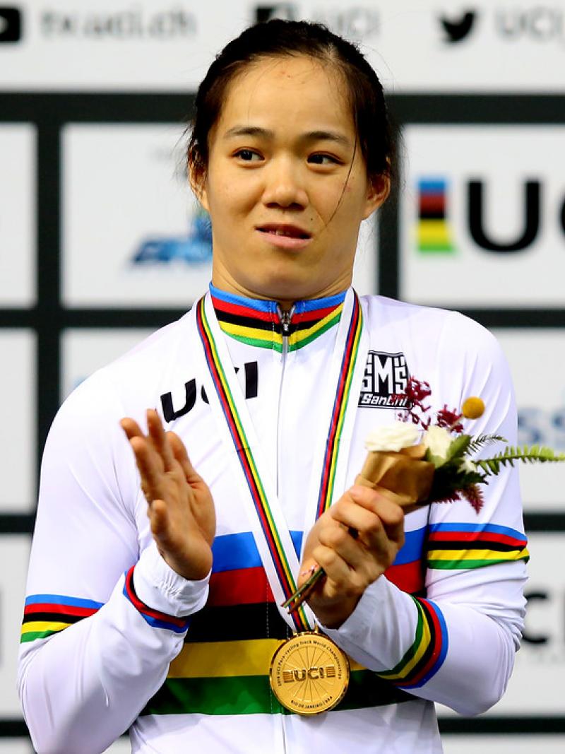 A female Para cyclist applauds on the podium
