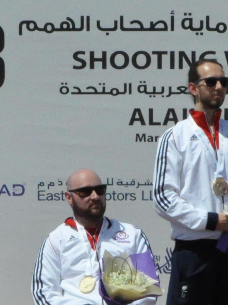 three male Para shooters on a podium