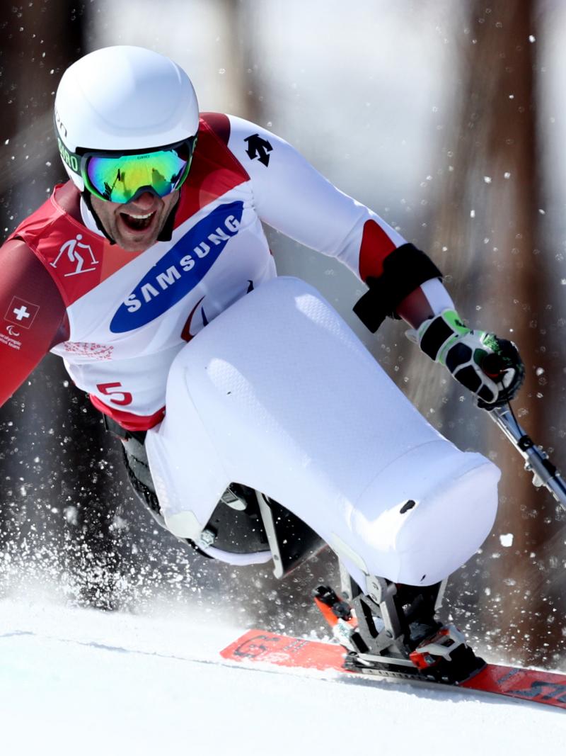 a male sit skier goes down the slope