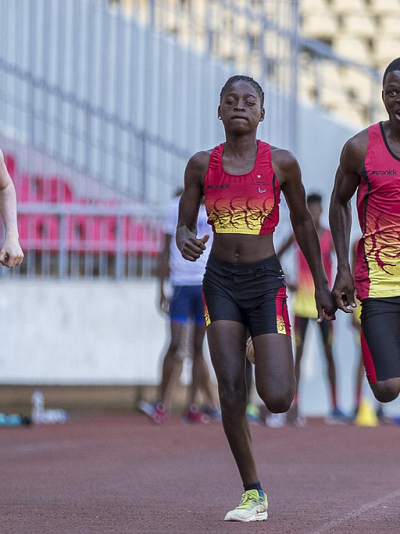 Three athletes running on a track