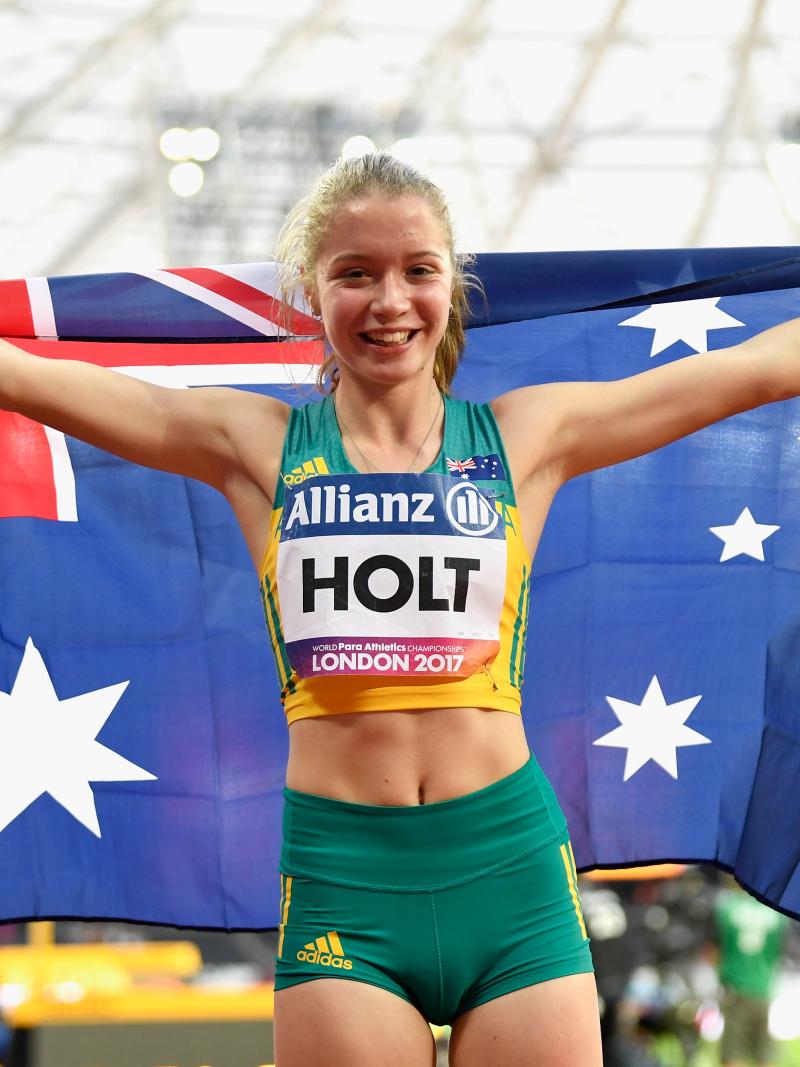 a female Para sprinter holding up the Australian flag