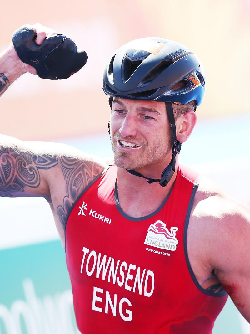 a male Para triathlete celebrates winning the race