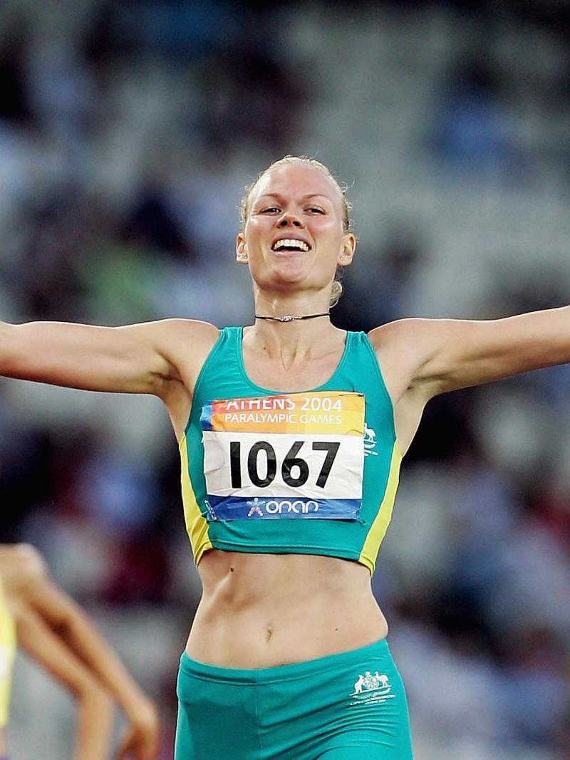a female sprinter crosses the line as winner