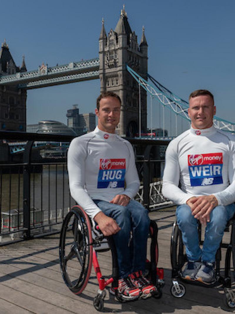 Two men in wheelchairs in London with the Tower Bridge in the background