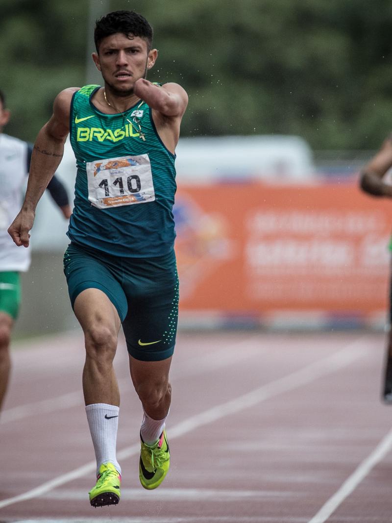 Three athletes running on an athletics track